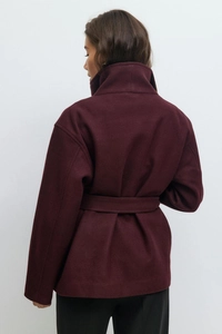 Back view of burgundy wool coat showing high collar, waist belt, and premium texture