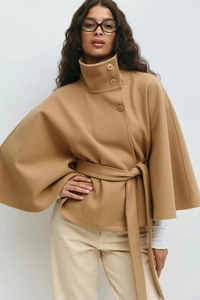 Detail of high neck camel wool cape coat with decorative buttons and matching waist belt