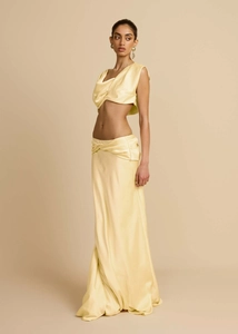 Detail von blassgelbem Satin-Crop-Top und Maxirock-Set mit drapiertem Seidenstoff