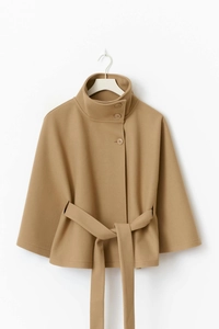 Detail view of camel wool cape coat featuring a high collar and side button closure