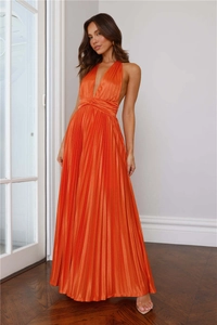 Détail d'une robe longue en satin plissé orange brillant avec taille ajustée élégante