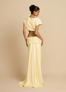 Detail eines eleganten gelben Satin-Zweiteilers mit kurzem Top und langem gerafftem Rock