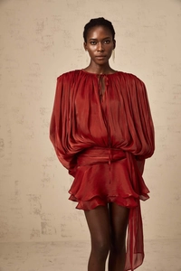 Detail of dark red puff sleeve mini dress featuring glossy fabric and ruffled hemline