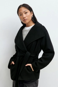 Detail of a black wool coat with wide lapels and a matching waist belt for autumn fashion
