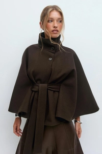 Close-up of deep brown wool cape coat featuring high collar and large matching buttons