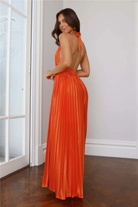 Détail d'une élégante robe de soirée en satin orange avec dos nu et plissé sophistiqué