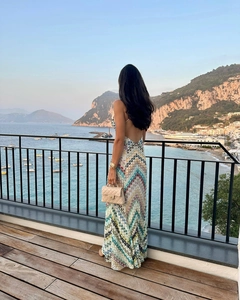 Robe longue dos nu à motif chevron coloré sur un balcon avec vue sur mer