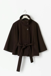 Detail of high neck dark brown wool poncho coat with buttons and tie waist belt