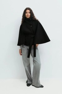 Close-up of black high-collar wool poncho with elegant large buttons and belted waist