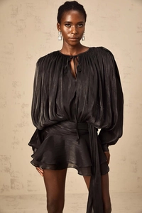 Close-up of black pleated fabric and tie-neck detail on elegant puff sleeve dress