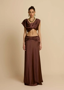 Detail eines dunkelbraunen Satin-Zweiteilers mit drapiertem Crop-Top und Maxirock mit hoher Taille