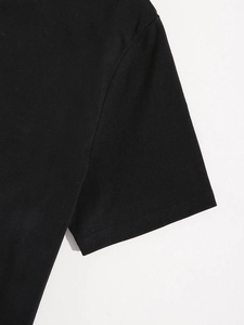 Gros plan de la manche du t-shirt noir en coton avec couture nette et maille lisse