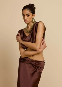 Detail eines schokoladenbraunen Satin-Zweiteilers mit drapiertem Top und Knotendesign