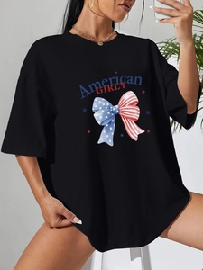 Détail de l'imprimé American GIRLY et du motif noeud sur un t-shirt noir surdimensionné