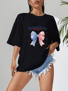 Détail d'un t-shirt noir oversize avec imprimé nœud drapeau américain et texte GIRLY