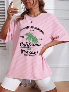 Close-up of pink oversized T-shirt with palm tree graphic and Summer Adventures text