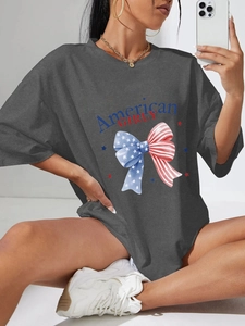 Détail de l'imprimé nœud drapeau américain et texte sur un t-shirt gris coupe ample