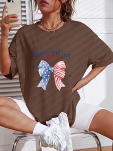 Détail d'un t-shirt oversize marron café avec imprimé American GIRLY et nœud rouge