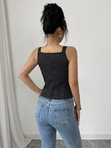 Slim fit black striped sleeveless tank top for women shown with light blue denim jeans