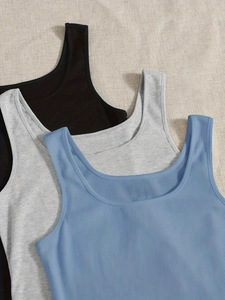 Set di tre canotte a costine senza maniche nei colori nero, grigio e blu su sfondo in tessuto