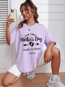 Detail van lavendelkleurig oversized Moederdag T-shirt met print en babyvoetafdrukken