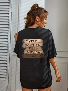 T-shirt nera casual con stampa Stay Positive sul retro e sfondo con ombre di persiana