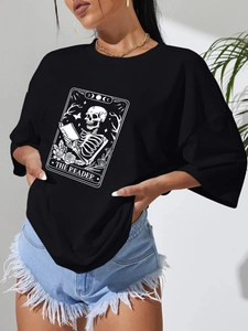 Detail eines schwarzen Oversize-T-Shirts mit Tarot-Print und lässigen Denim-Shorts