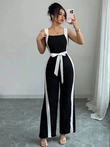 Contrast black and white jumpsuit with spaghetti straps and waist bow in a wide-leg cut