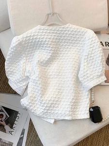 Elegant white short sleeve popcorn textured blouse with puff sleeves and crew neck