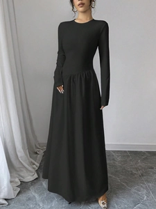 Detailansicht des eleganten schwarzen Langarmkleids mit Taillenfalten und ausgestelltem Saum