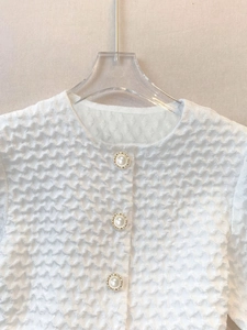 Elegant white short sleeve blouse with textured waffle fabric and pearl buttons
