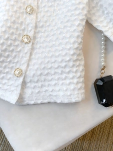 Elegant white short-sleeve shirt with bubble texture fabric and pearl button detail