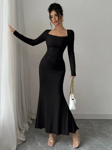 Close-up of the elegant waist ruching and mermaid hem of the black long sleeve dress