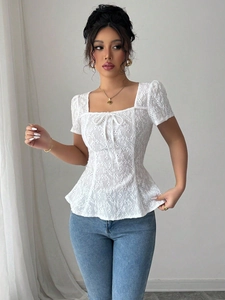 Detalle de blusa de encaje blanco con cuello cuadrado y delicado bordado floral