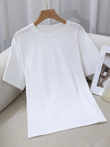 Detail van zachte witte katoenen t-shirtstof en klassieke ronde hals op houten hanger