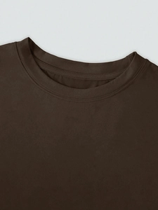 Close-up of the dark brown crew neck with double-needle stitching on a simple t-shirt
