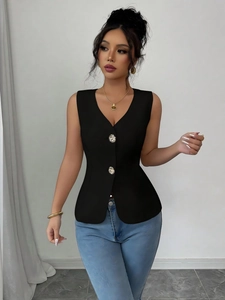 Detail of slim fit black sleeveless waistcoat with golden vintage relief buttons