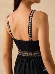 Detail of embroidered straps and elastic smocked back on a black summer jumpsuit