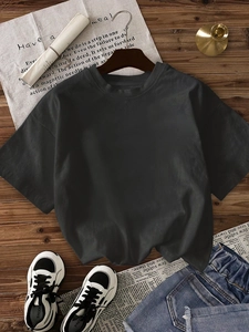 T-shirt oversize gris anthracite à col rond sur fond en bois naturel