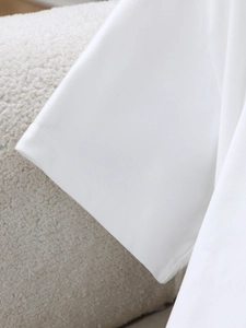 Close-up of white t-shirt sleeve cuff showing neat stitching and soft cotton fabric