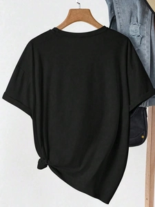 Close-up of a black crew neck T-shirt featuring a stylish side knot detail on the hem