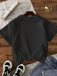 Women's casual black crew neck t-shirt paired with denim shorts on a dark wood floor