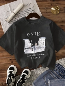 T-shirt noir femme avec imprimé Paris présenté à plat sur fond en bois naturel