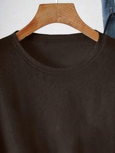 Detail of a dark coffee crew neck t-shirt on a wooden hanger with denim accent