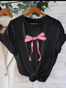 Women's black casual t-shirt featuring a large pink ribbon bow print and knotted hem detail