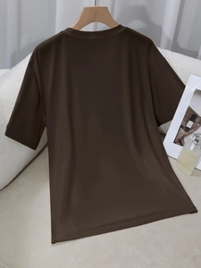 Koffiebruin T-shirt met ronde hals aan een houten hanger tegen een zachte witte achtergrond