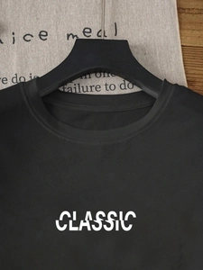 Detail of classic white letter print on a black round neck short sleeve cotton T-shirt