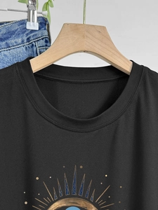Women's black cotton crew neck T-shirt with artistic golden and blue print on wood hanger