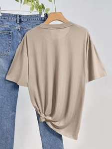 Λεπτομέρεια χακί T-shirt με στρογγυλή λαιμόκοψη και κομψό πλαϊνό κόμπο στο στρίφωμα