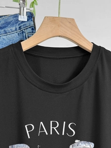 Close-up of black cotton T-shirt featuring white PARIS text and grey city architecture print